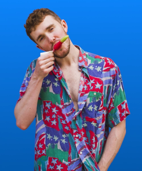 Caucasian male model in geometric pattern short sleeve shirt eating ice cream