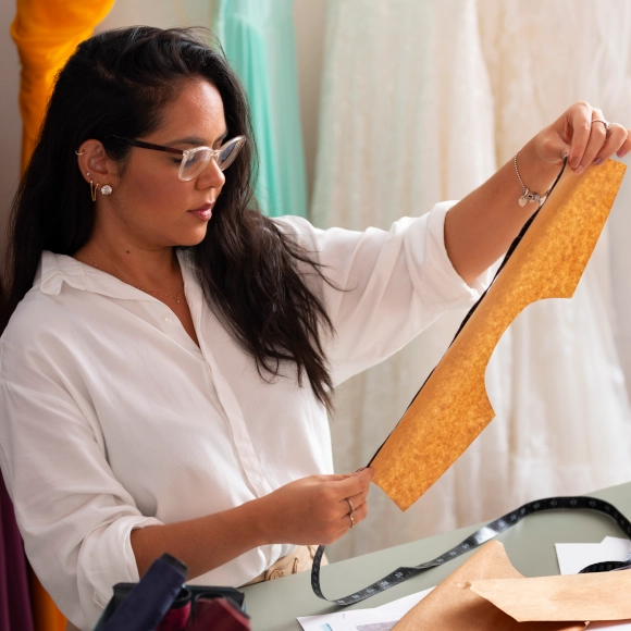 female fashion designer holding up piece of fabric